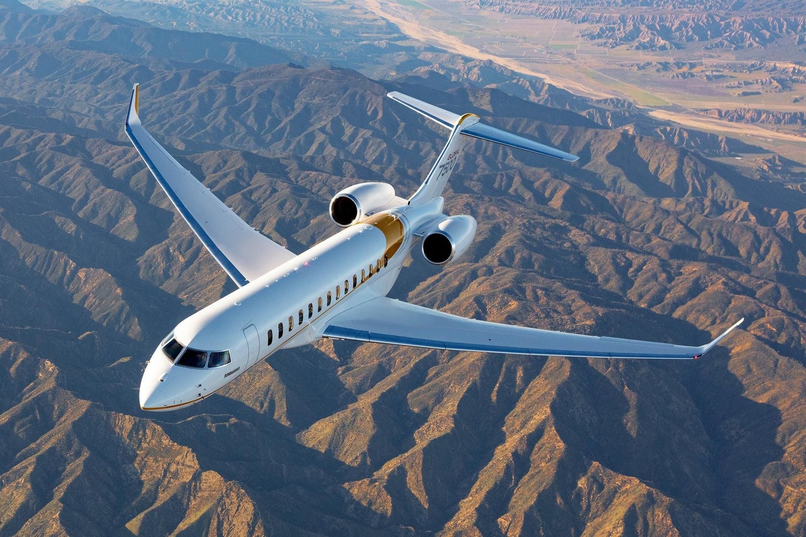 Bombardier Global 7500 business jet soaring over mountainous terrain