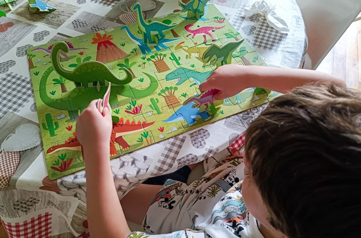 Boy concentrating on assembling a dinosaur puzzle