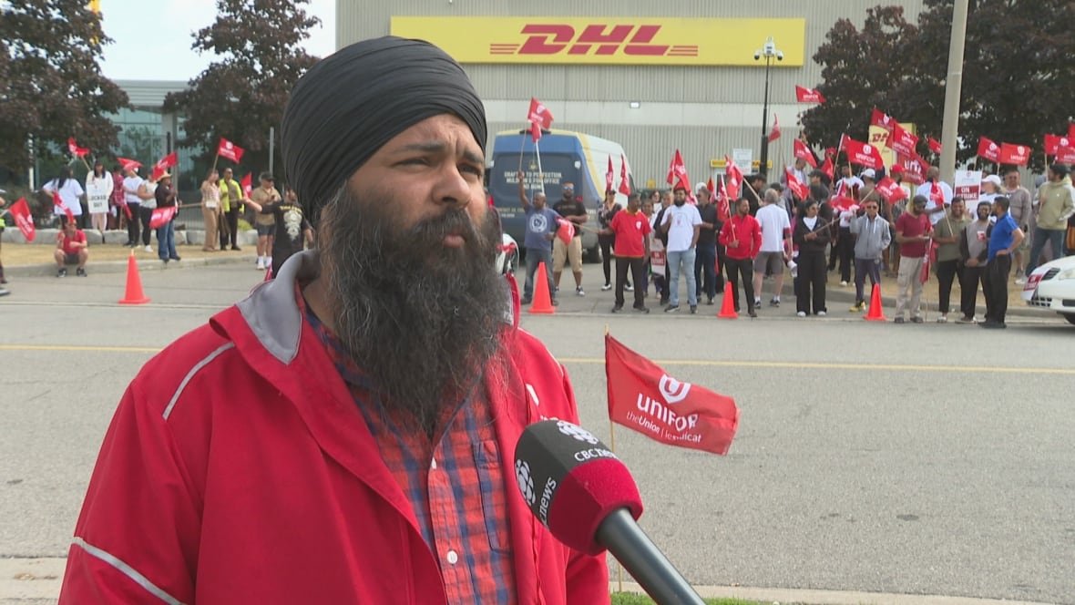 Unifor representative addressing striking workers outside DHL facility