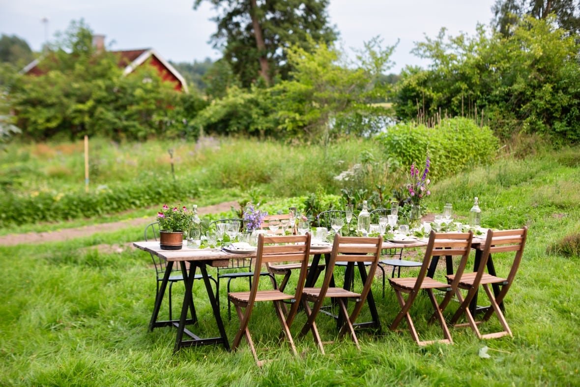 Rustic outdoor dining surrounded by vibrant greenery