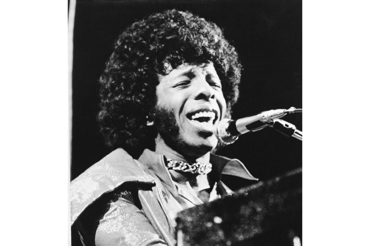 Sly Stone performing passionately on stage