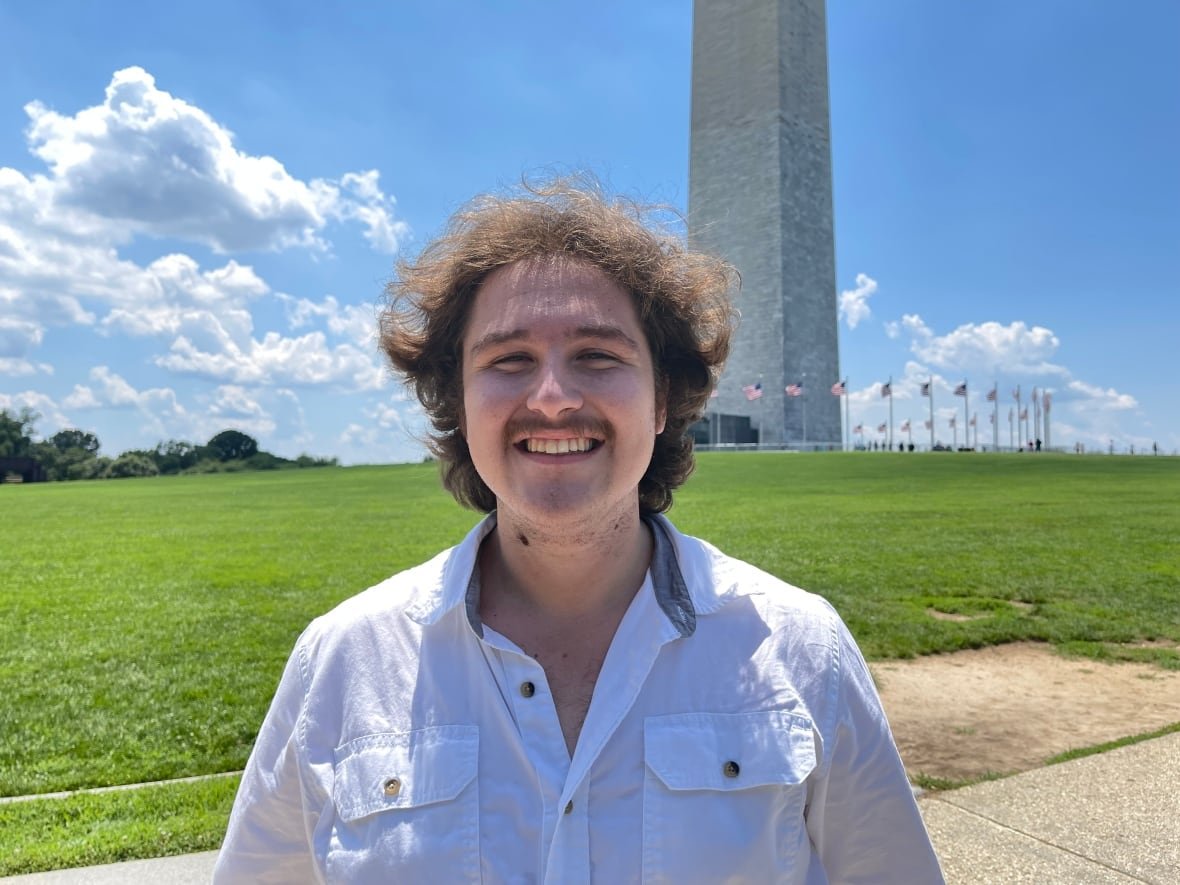 A young man standing near a national monument.