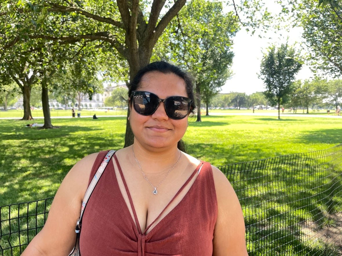 Young woman wearing glasses standing near park