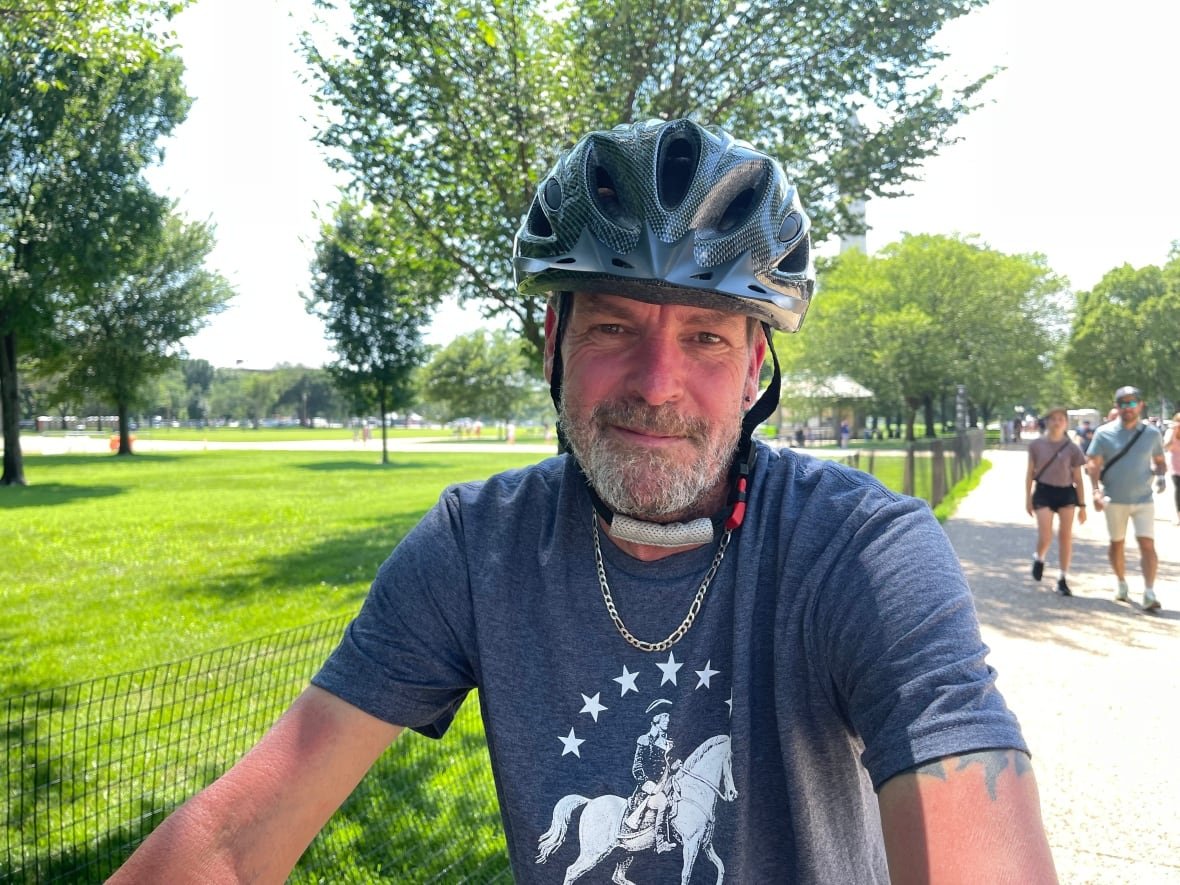 Man wearing bicycle helmet near park