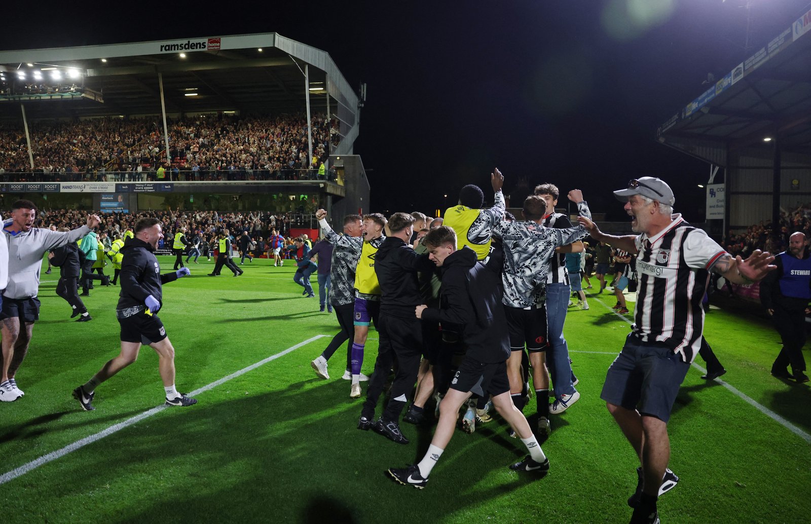 Grimsby‍ Town⁤ fans⁤ celebrating‌ pitch invasion after win versus Man utd