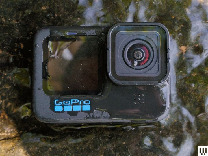 Compact black action camera resting on rocky terrain