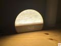 Hatch Restore 3 semicircular shaped alarm clock glowing softly on wooden nightstand