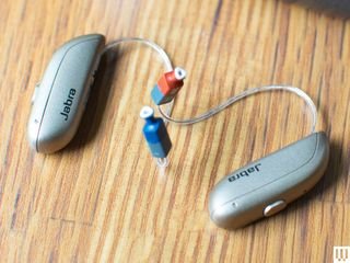 Jabra Enhance Select 300 close up of two silver behindtheear hearing aids on a wooden surface