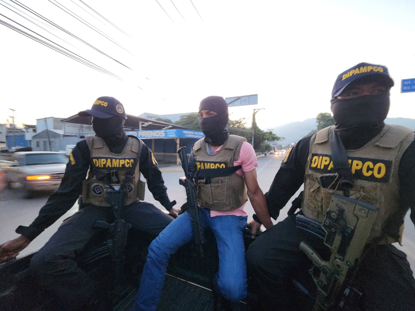 DIPAMPCO officers wearing helmets and masks patrol during daytime in San Pedro Sula