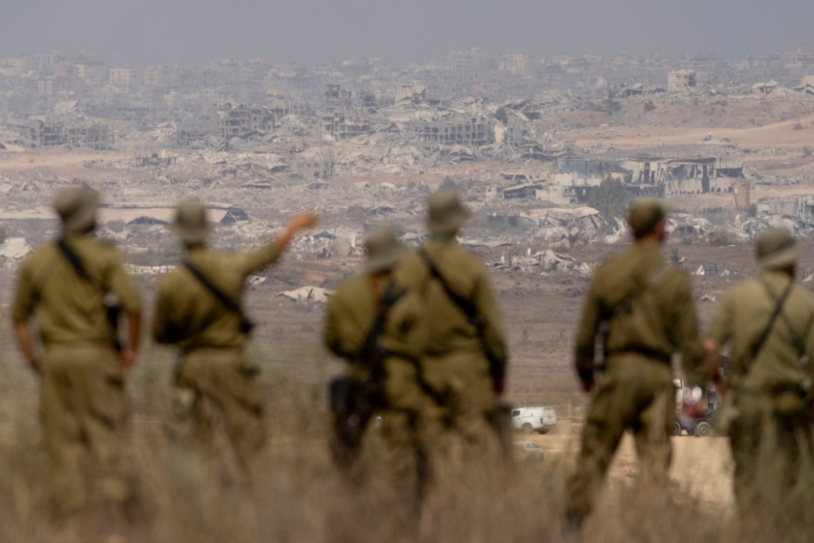 Israeli soldiers surveying damaged buildings near northern Gaza border