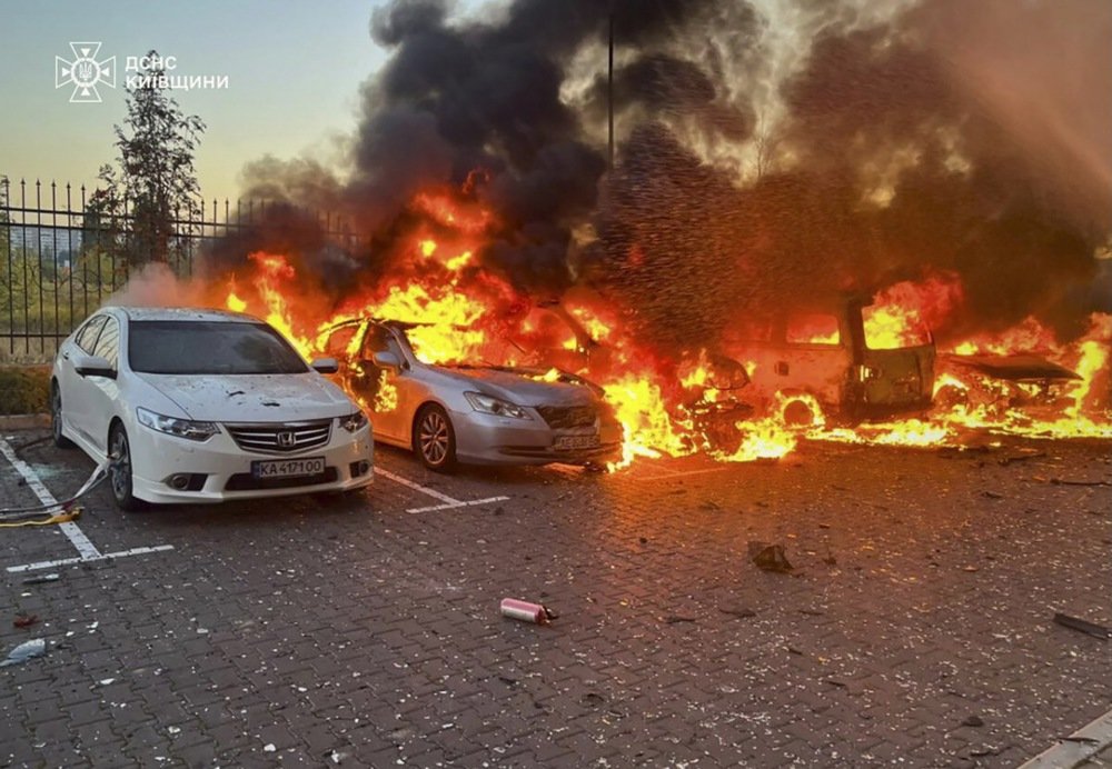 Vehicles ablaze after a drone strike near a residential area in Kyiv, Ukraine, amid ongoing hostilities.