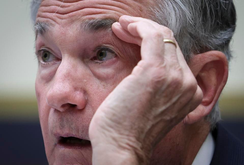 Federal reserve chair Jerome Powell with symbols representing bitcoin and gold