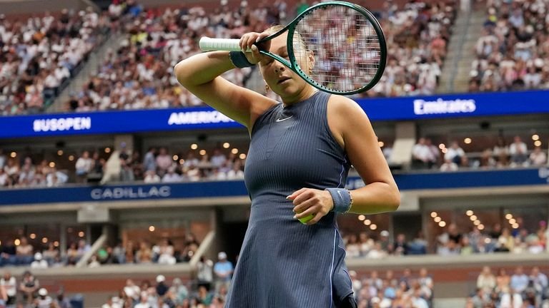 Amanda Anisimova wiping sweat between serves