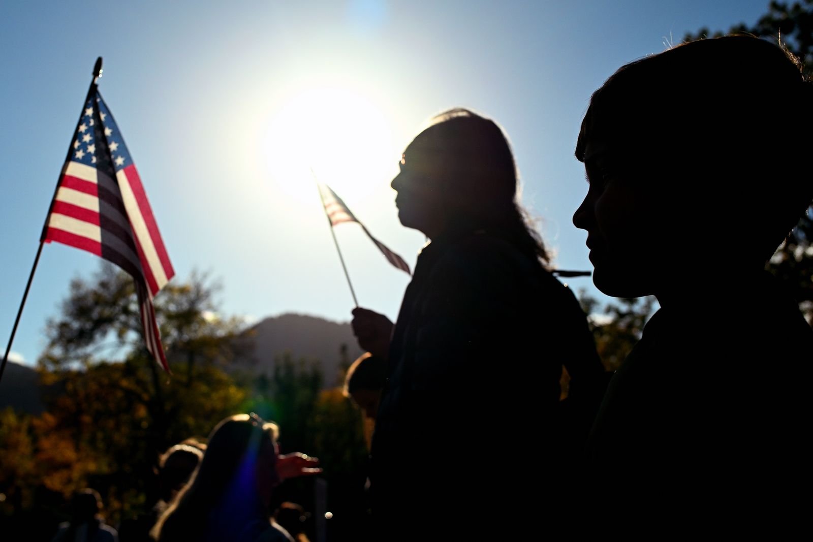 Silhouetted protesters marching at dusk in Boulder
