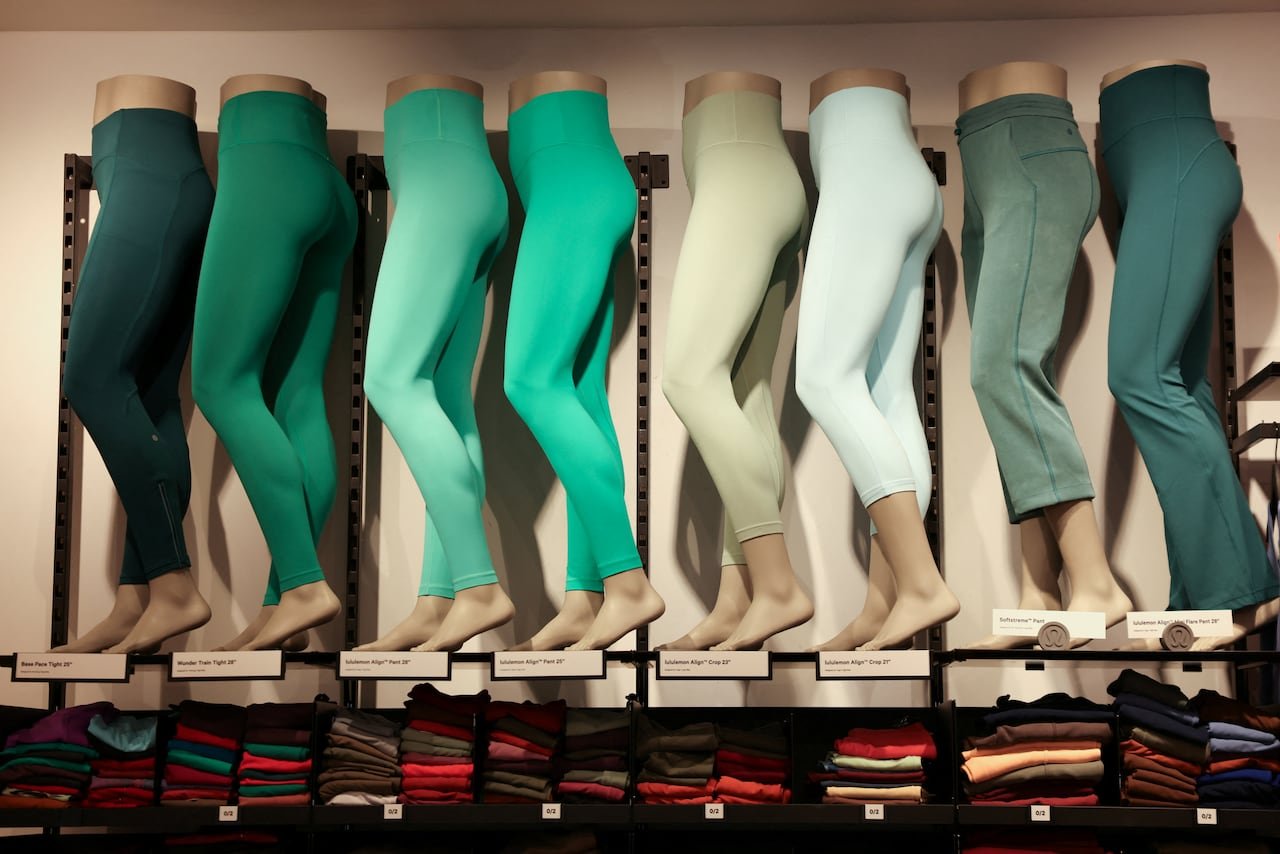Various styles of green athletic leggings displayed prominently inside a modern retail store