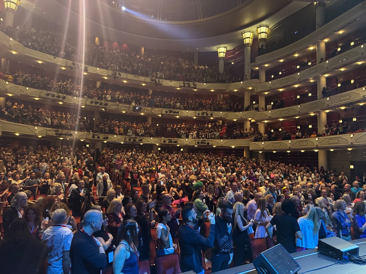 Audience enthusiastically standing during a Rocky horror screening.