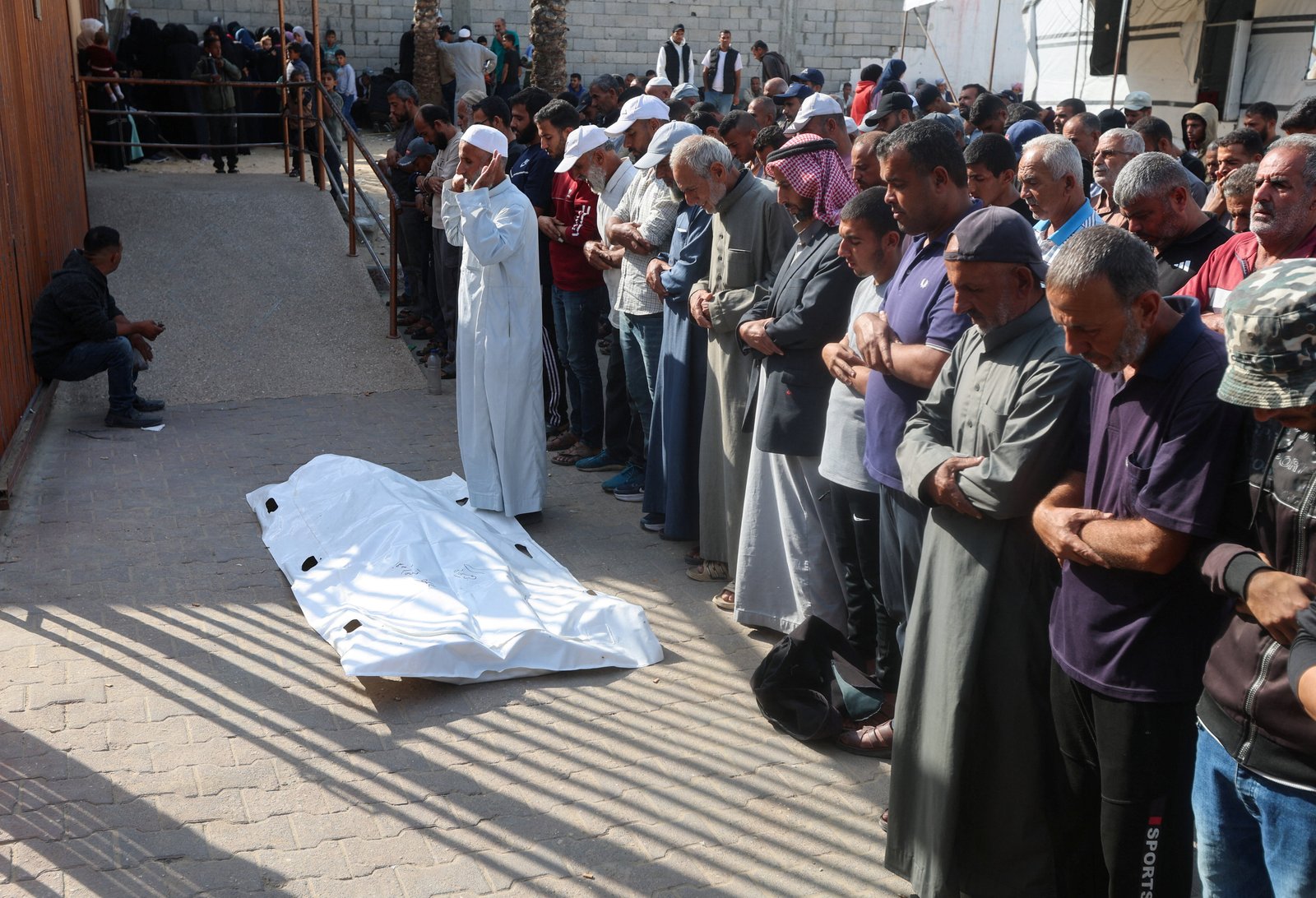 Mourners pray beside victim killed by Israeli fire