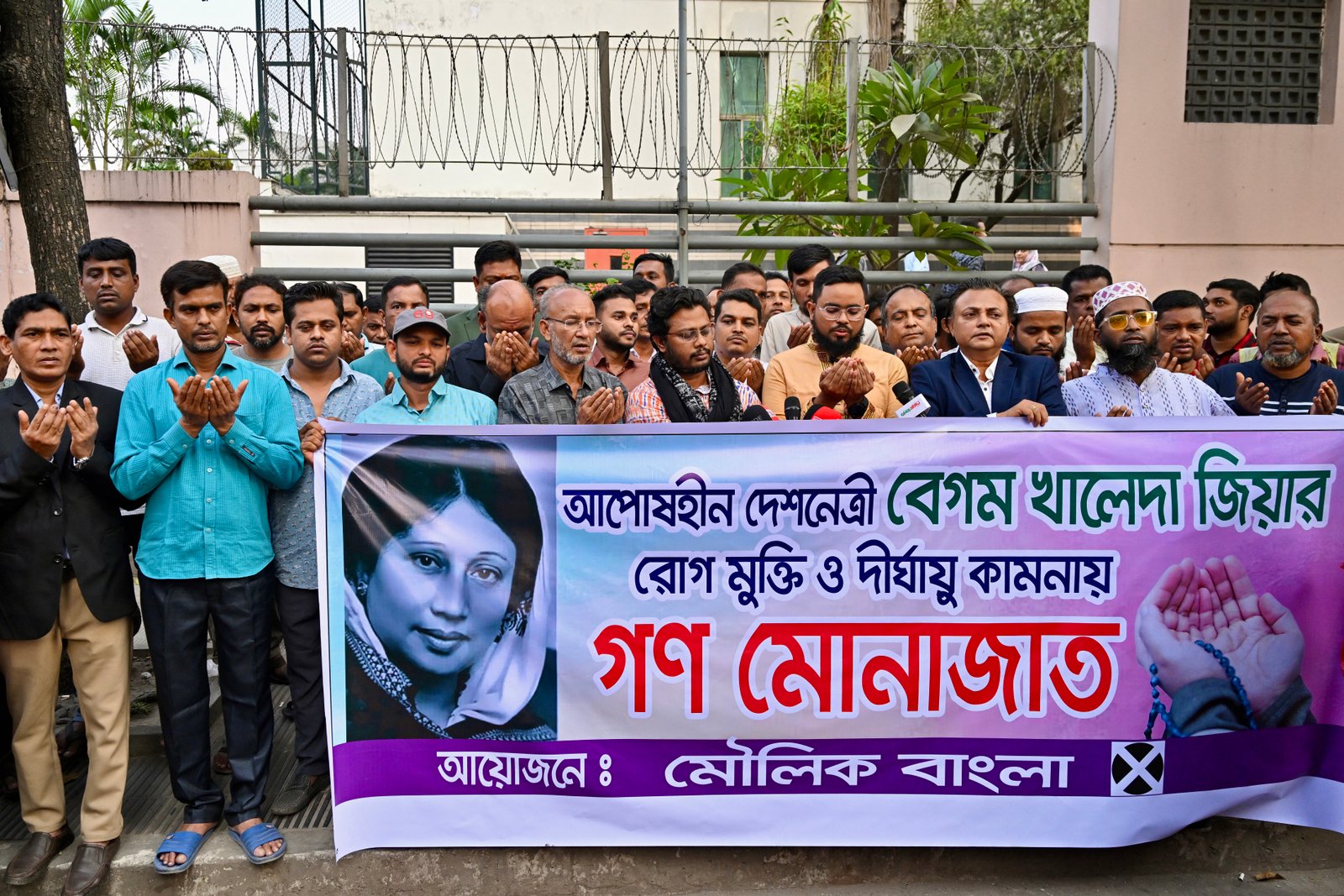 Supporters hold banner with portrait of former Bangladeshi PM khaleda Zia outside hospital