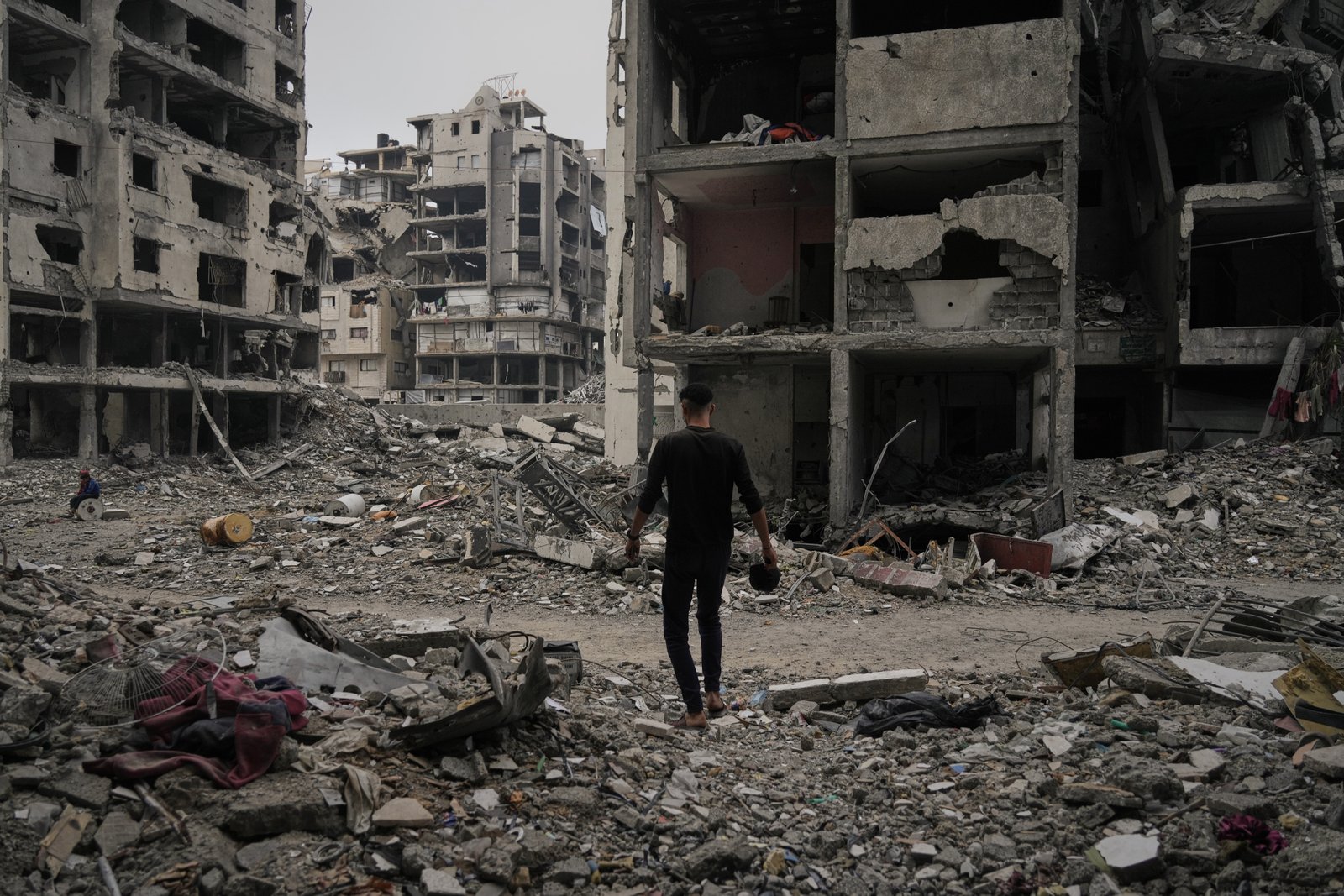 A Palestinian man walks among destroyed buildings in Gaza City