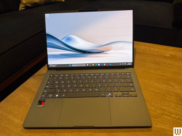 Front view of the Asus Zenbook A14 laptop while open with abstract art displayed on screen