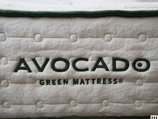 close-up view of Avocado Green Hybrid Mattress showing thick white side panel with green trim