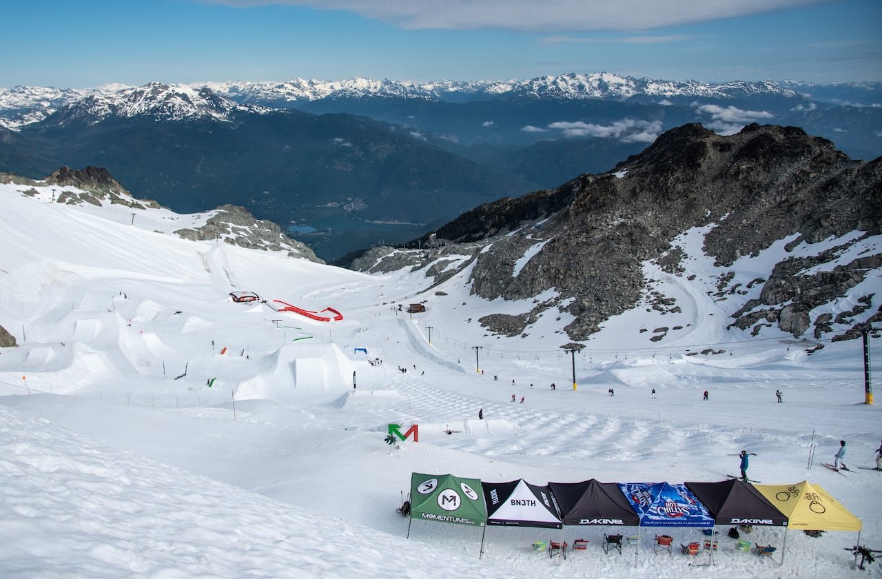 Panoramic view over snowy ski slopes under clear skies.