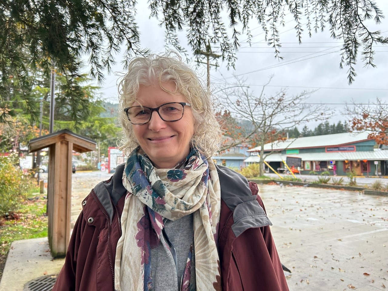 woman standing near shops overlooking greenery