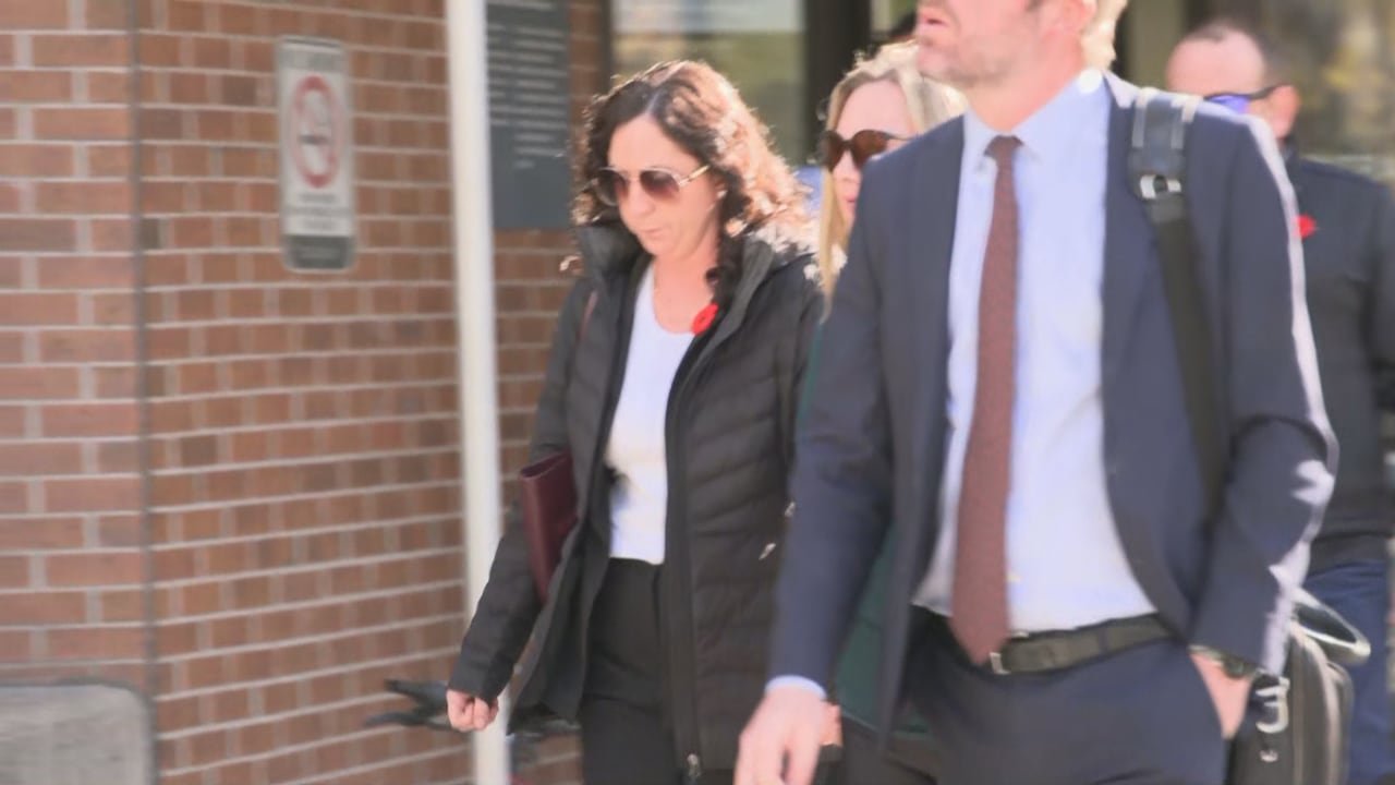 Woman leaving courtroom wearing sunglasses