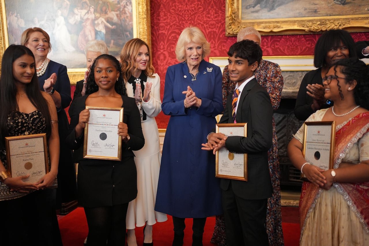 Queen Camilla standing among children winners.