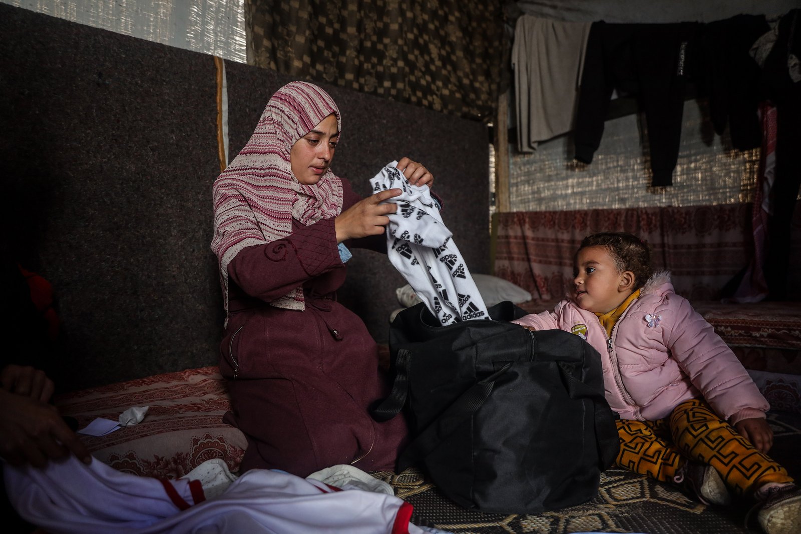 Mother Eman Abu Al-khair holding baby Mohammed's clothes bag after his death