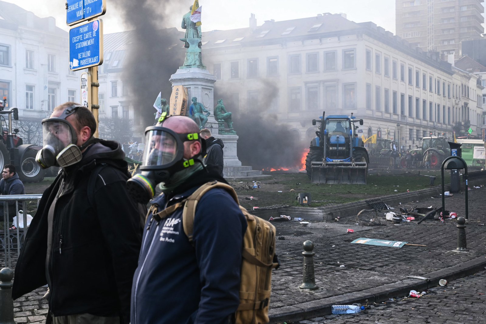 Farmers protesting near European Parliament in Brussels wearing protective gear