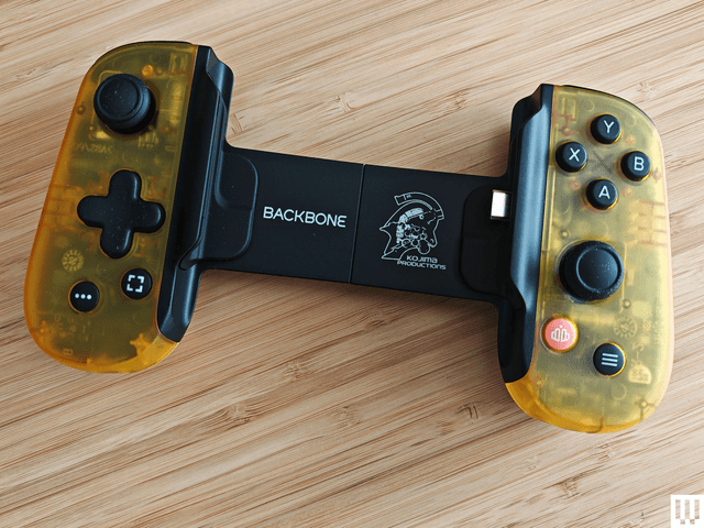 Yellow semi-clear video game controller with long backplate connecting each side. Left side has a joystick and directional pad. Right side has 4 buttons and a joystick.