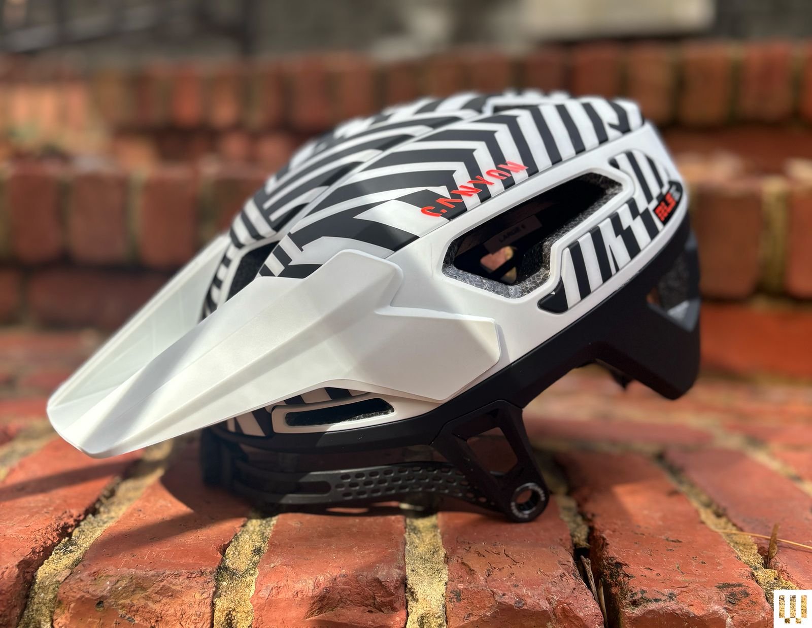Side profile view of sleek black-and-white Canyon Deflectr Trail RLS mountain bike helmet