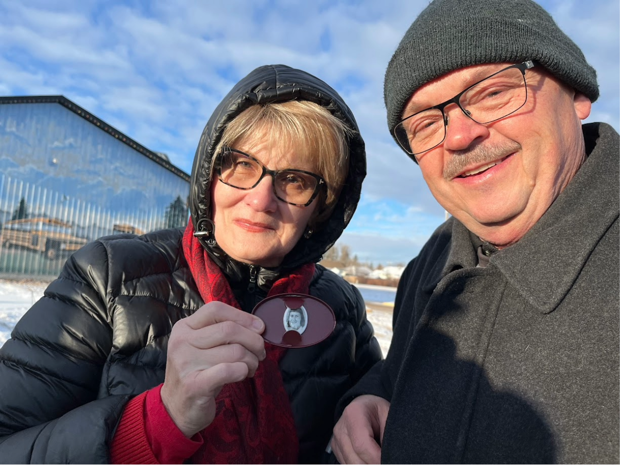 Woman holding photo of late sister during memorial event