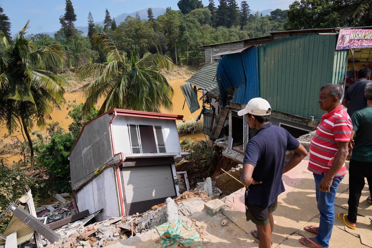 Locals inspecting flood-damaged structures near Peradeniya district Sri Lanka