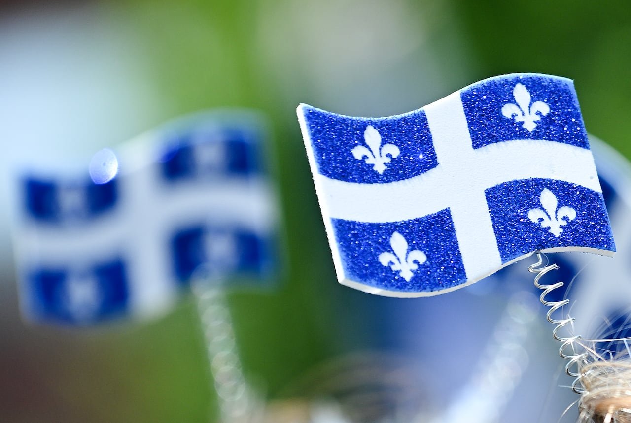 Quebecers celebrating Saint-Jean-Baptiste Day parade waving flags