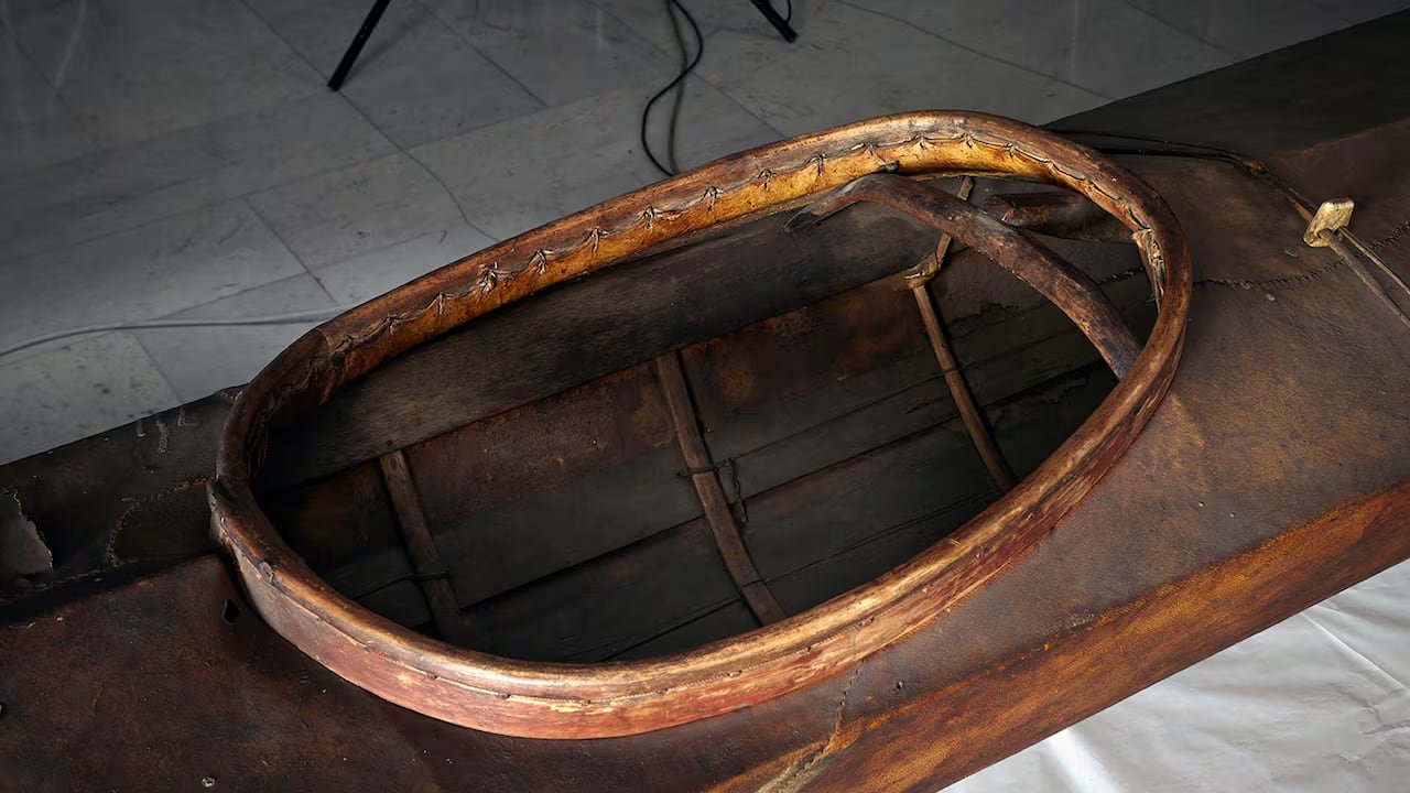 Close-up inside cockpit area showing detailed woodwork on traditional wooden kayak frame.
