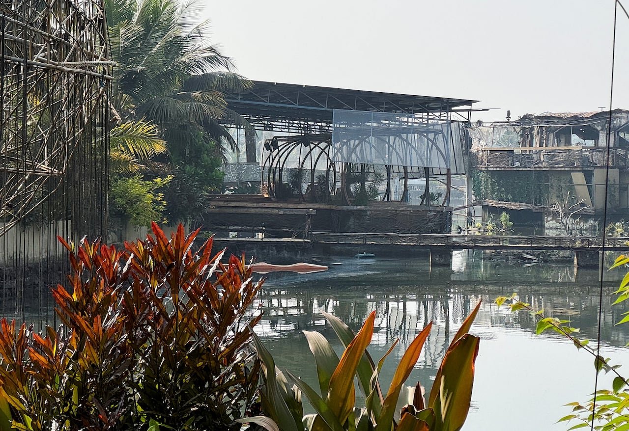 Burnt remains of a nightclub surrounded by lush greenery
