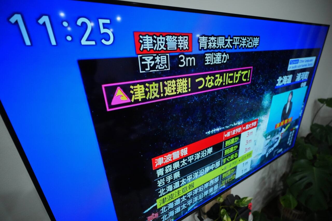 Emergency broadcast displaying tsunami warning text on Japanese TV screen