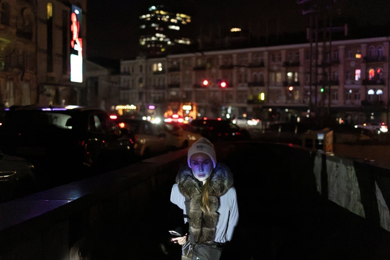 Woman walking at night in Kyiv amid blackout