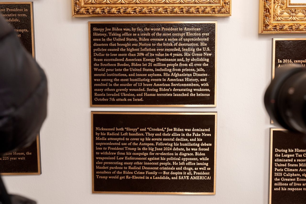 Plaques with black background and gold text hung on wall