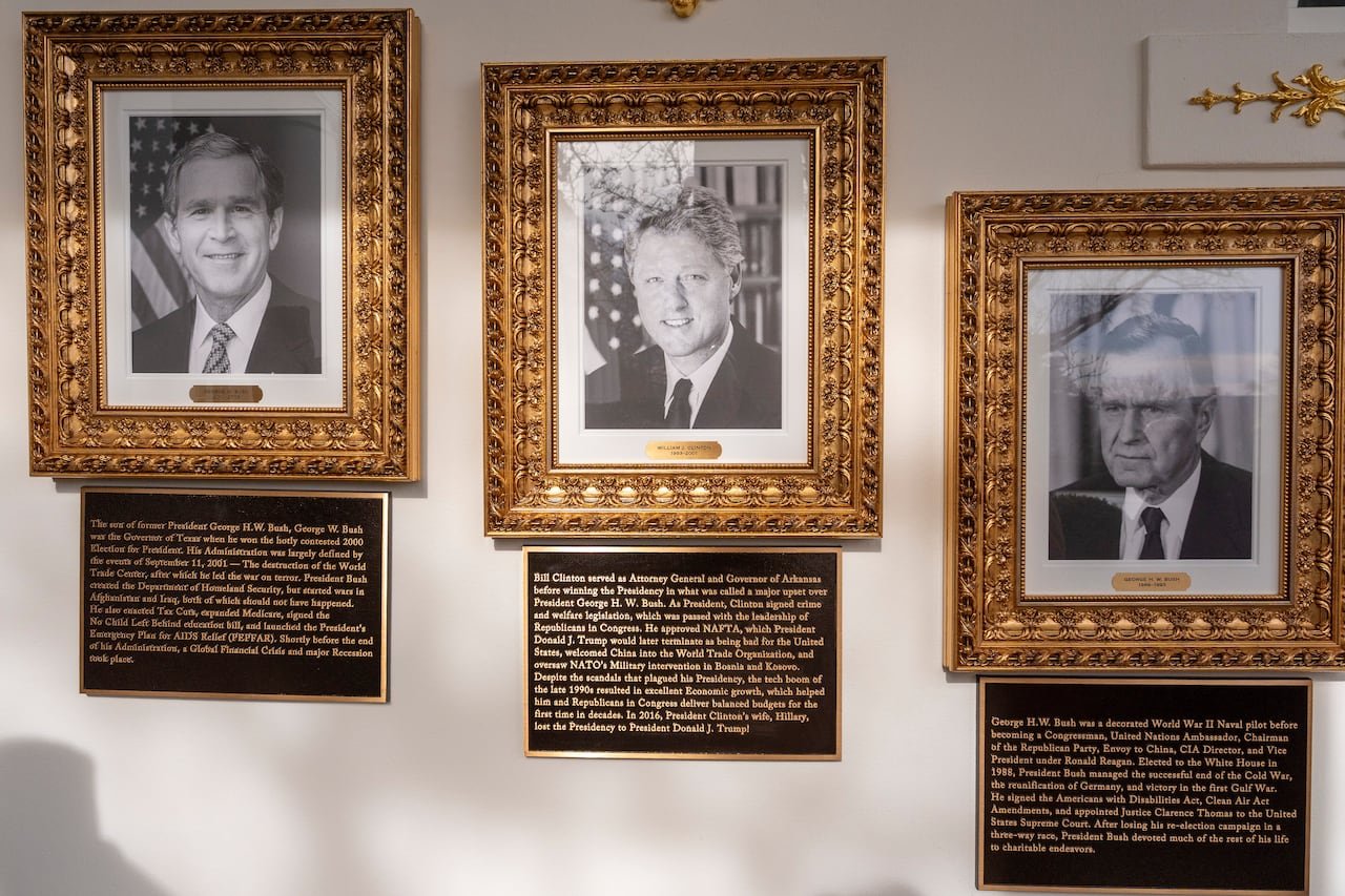 Presidential portraits with gold borders above textual plaques