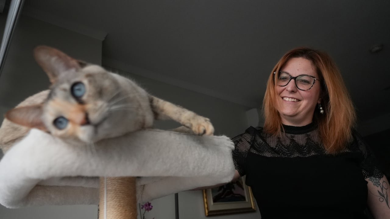 woman smiling gently while petting cat