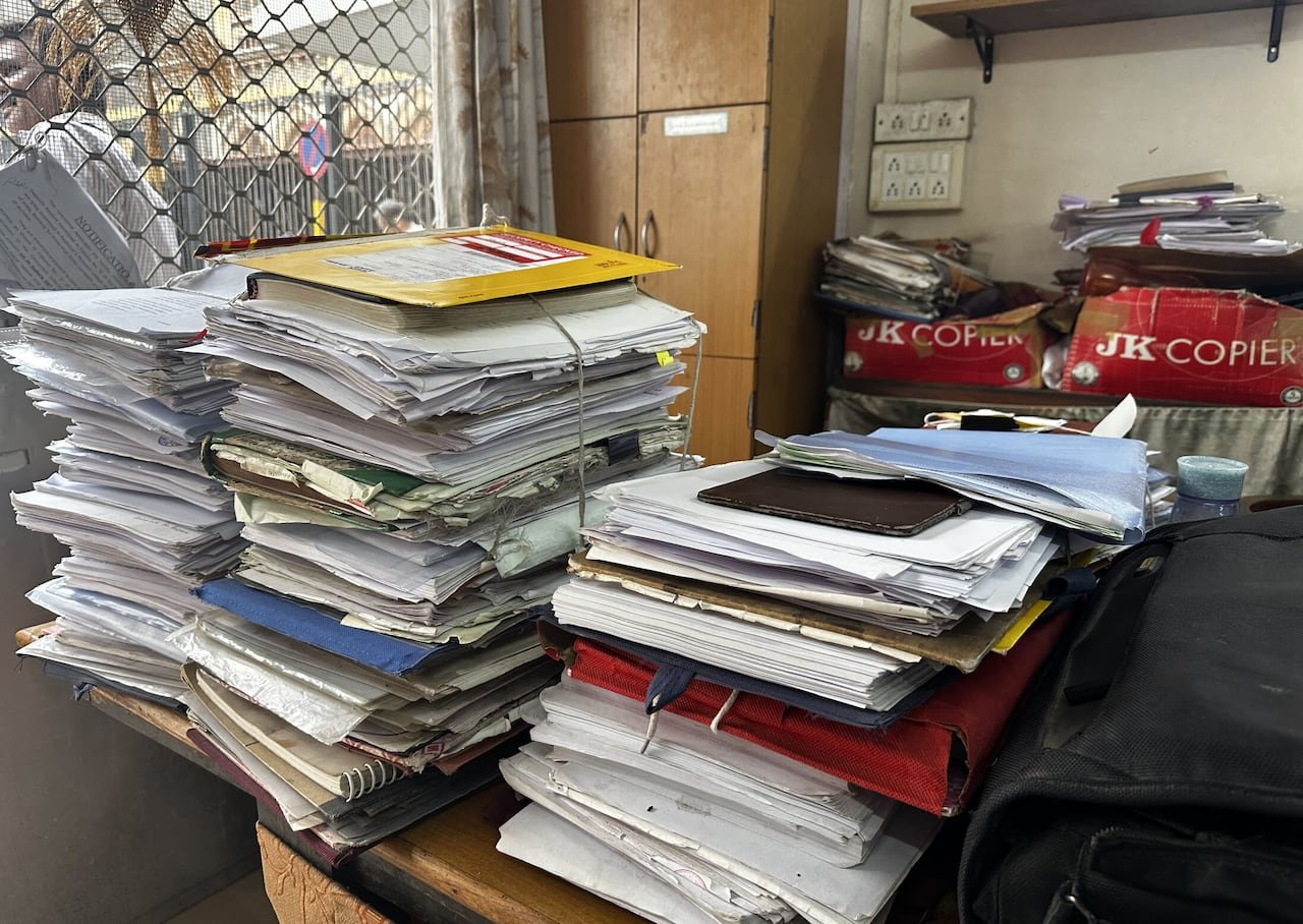 Stacks of court files piled high on desk