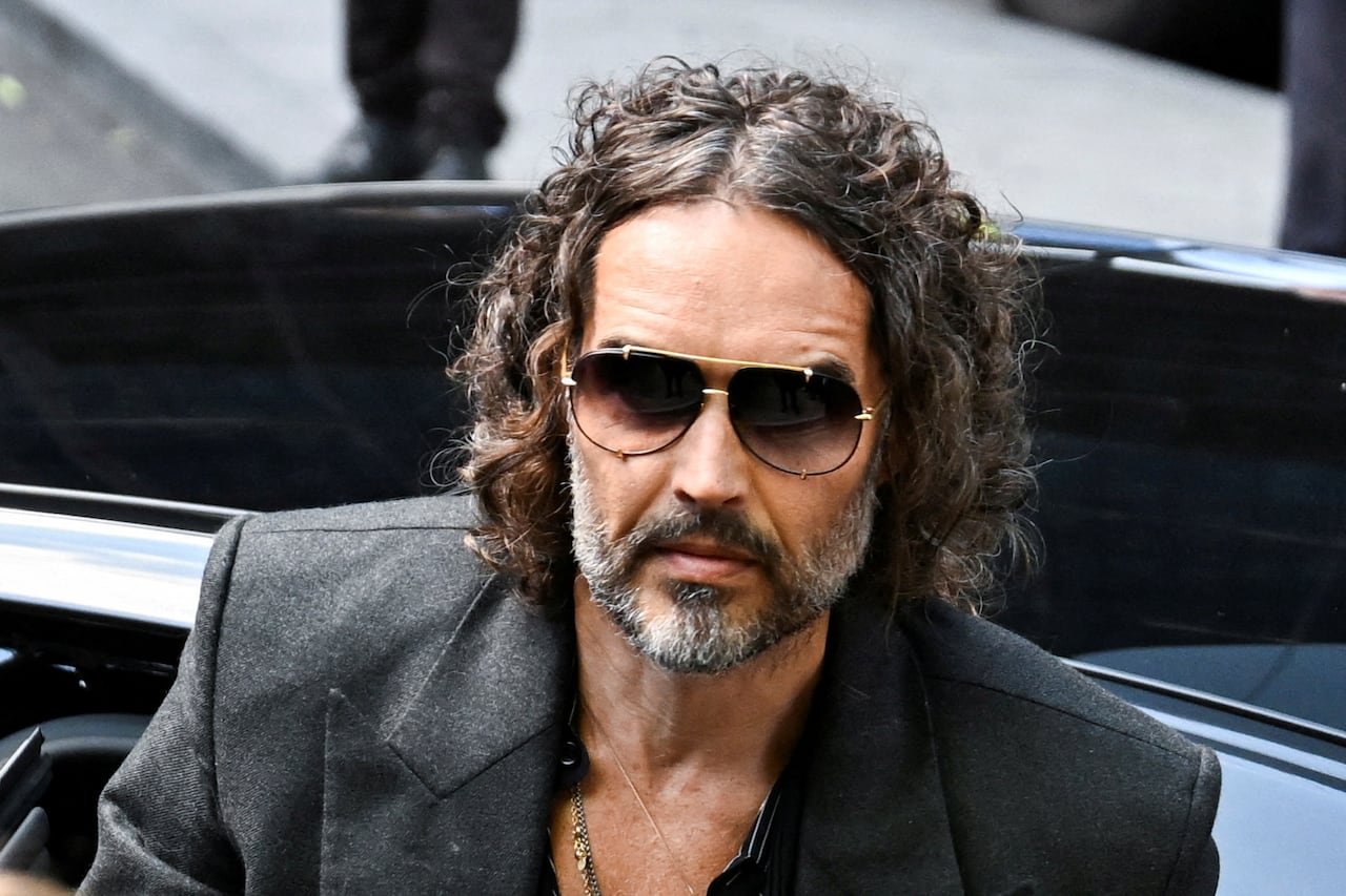 Russell Brand wearing sunglasses stepping out of car