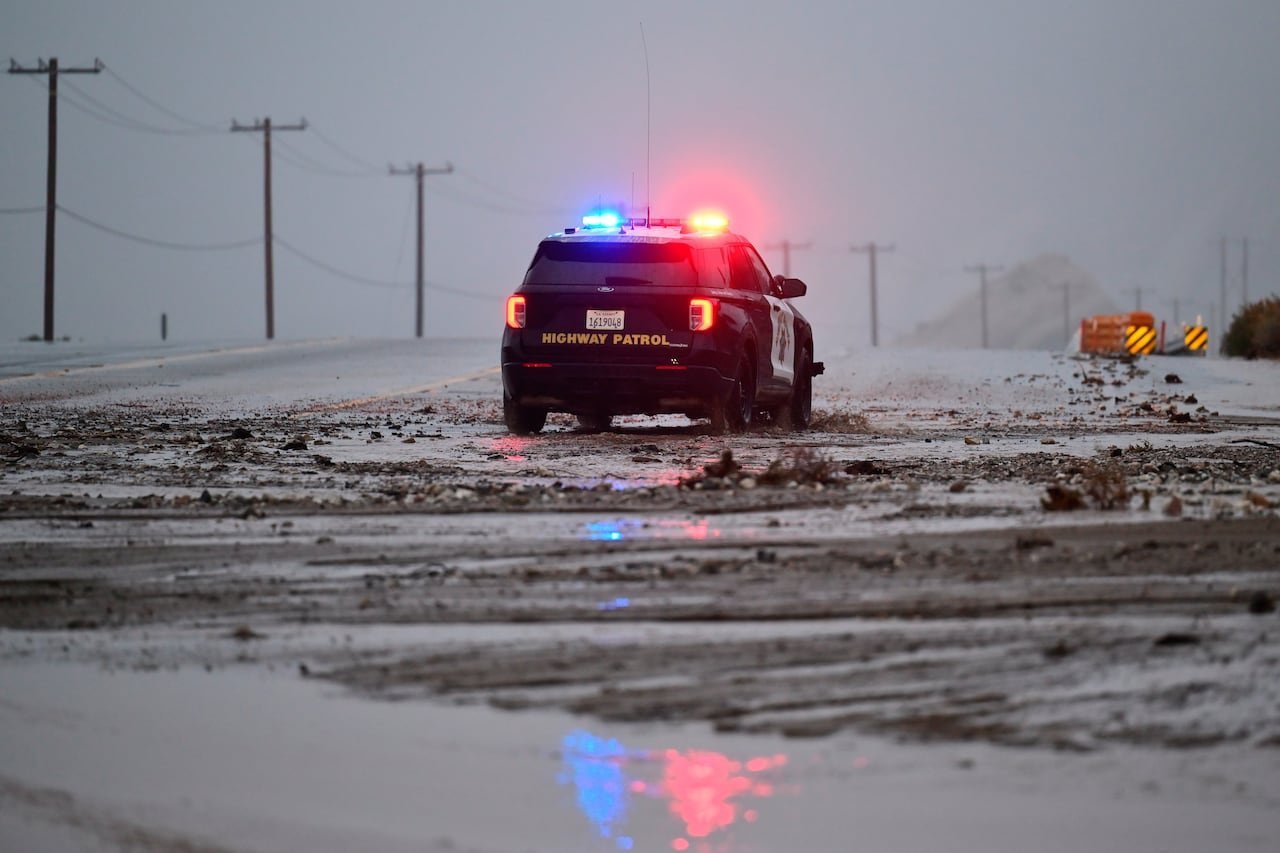 Highway patrol vehicle navigating muddy road near Wrightwood