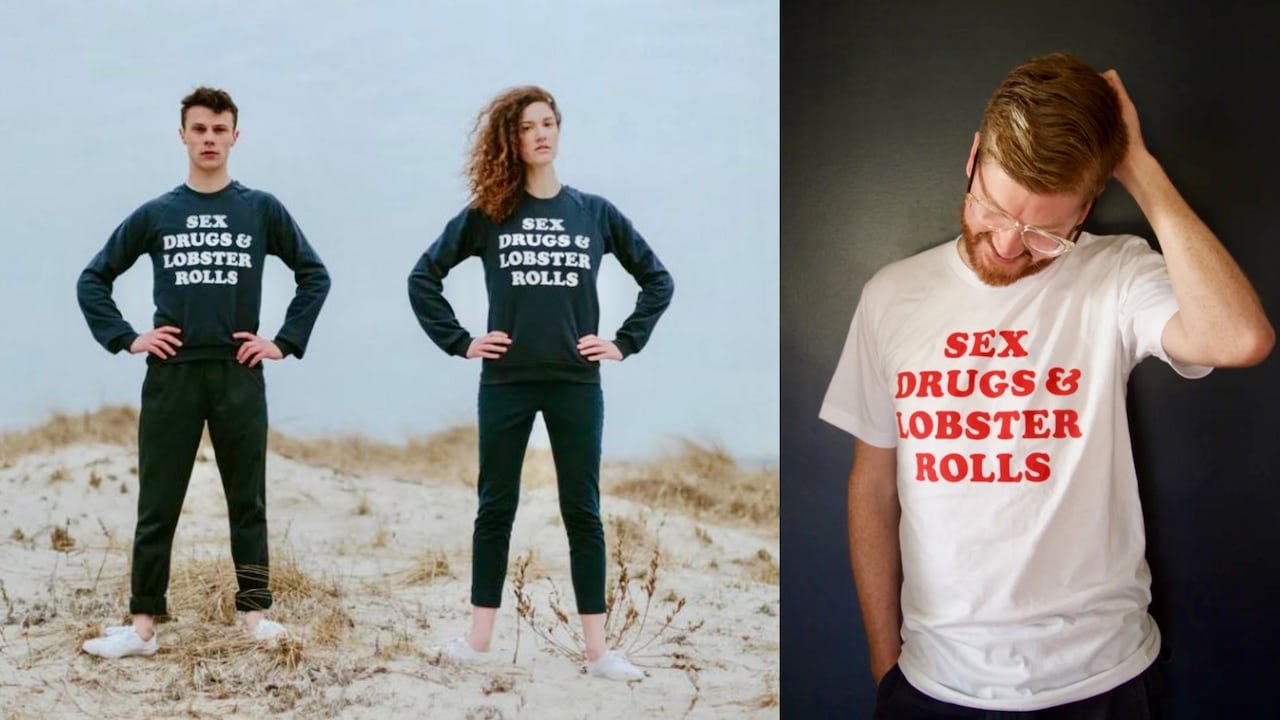 Two people standing near ocean shore wearing black clothing