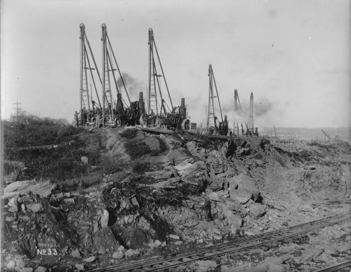 Steam-powered drills boring holes for explosives