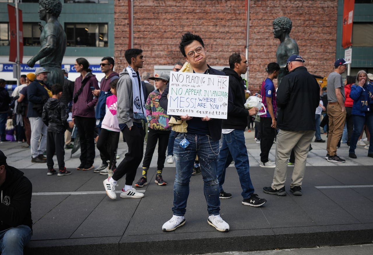 Disappointed fan holding sign outside stadium