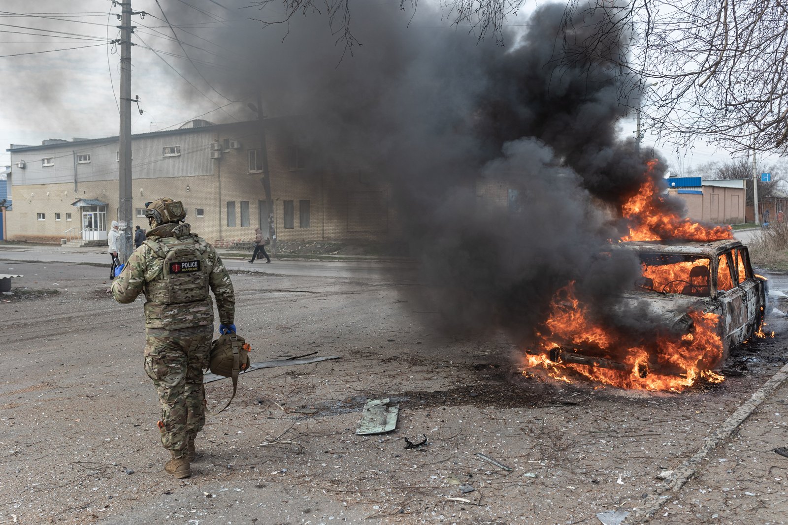DRUZHKIVKA, UKRAINE - JANUARY 13: Emergency responders attend to a car engulfed in smoke and flames after a Russian FPV drone strike in Druzhkivka, Ukraine on January 13, 2026. A civilian inside the vehicle was injured.